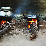 Pots simmering on a wood-burning mud stove.