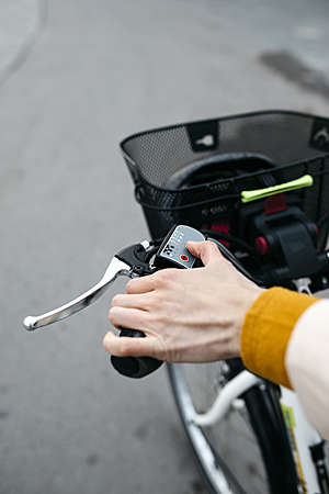 Close-up of a woman's hand connecting the electric motor on her e-bike.