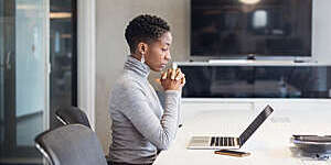 Side view of mature businesswoman looking at laptop and thinking.